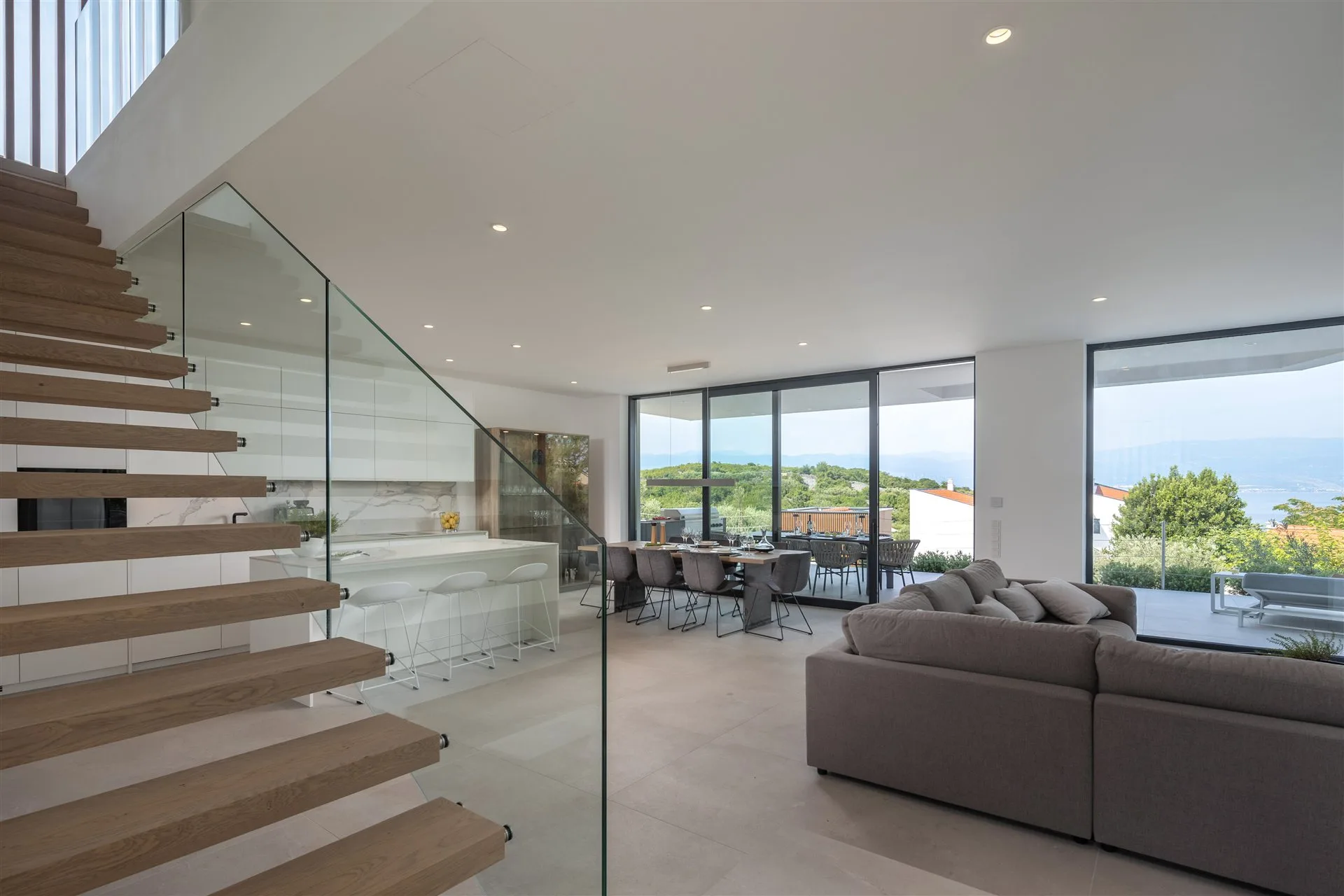 Villa Manatis schwebende Holztreppe mit Glasgeländer und Meerblick dahinter