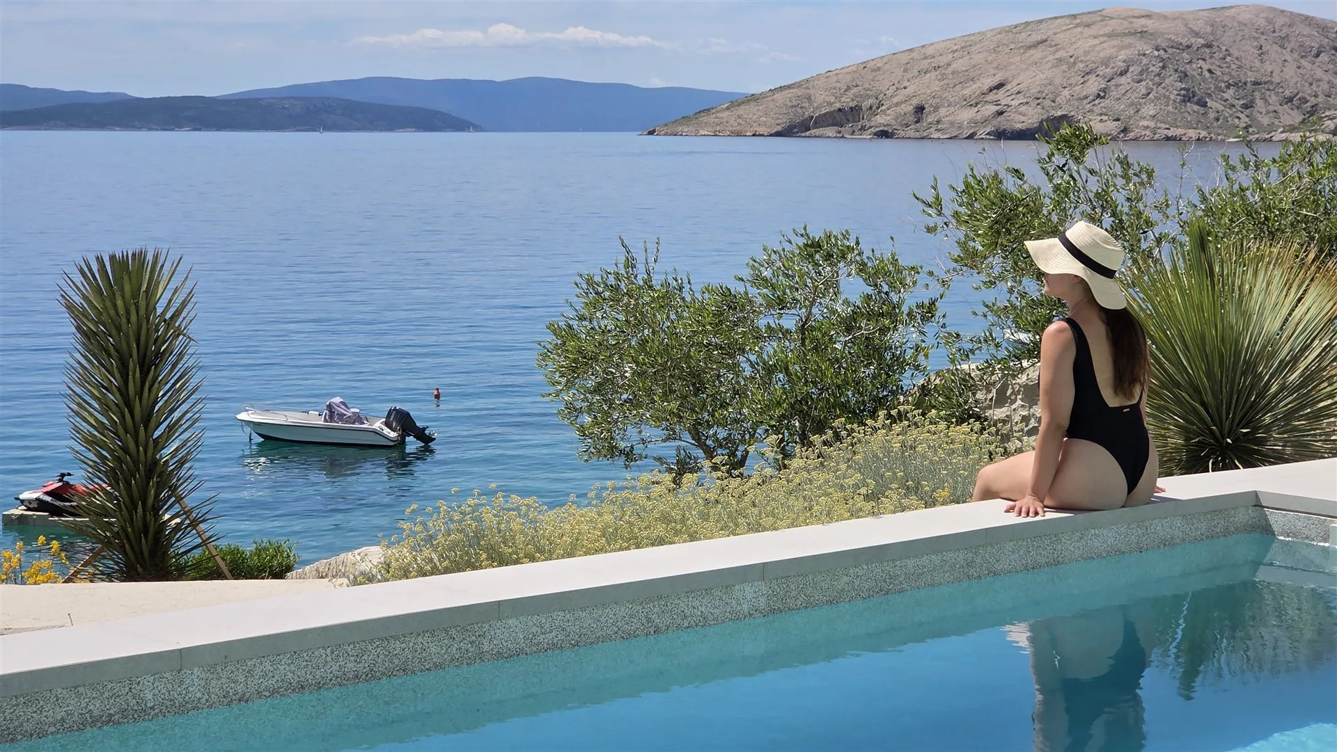 Entspannen am Poolrand mit Adriablick und Booten im Hintergrund