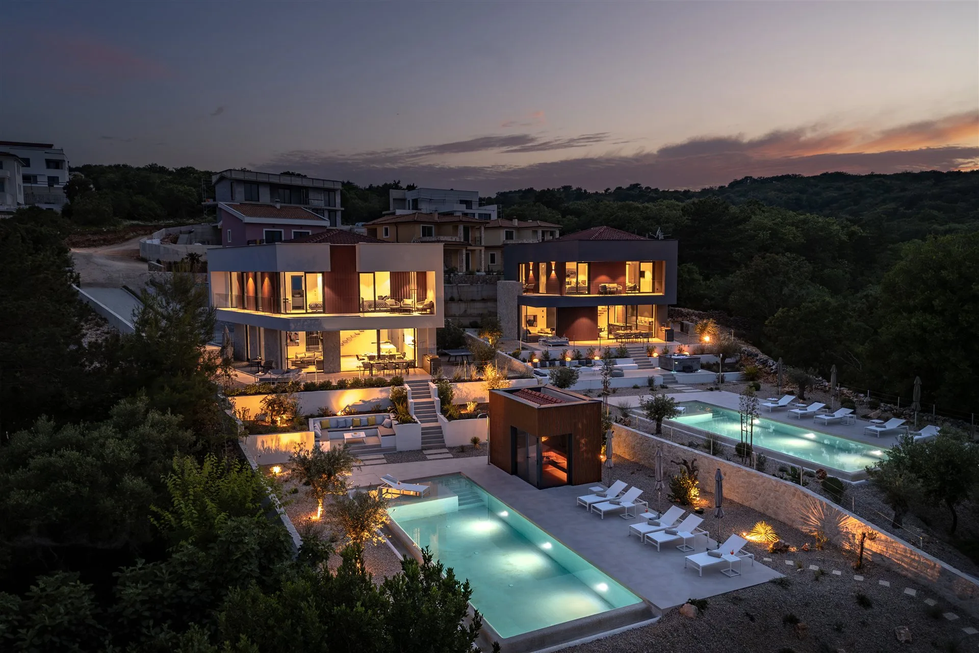 Villa Moana at twilight — glowing pools and illuminated villa from above