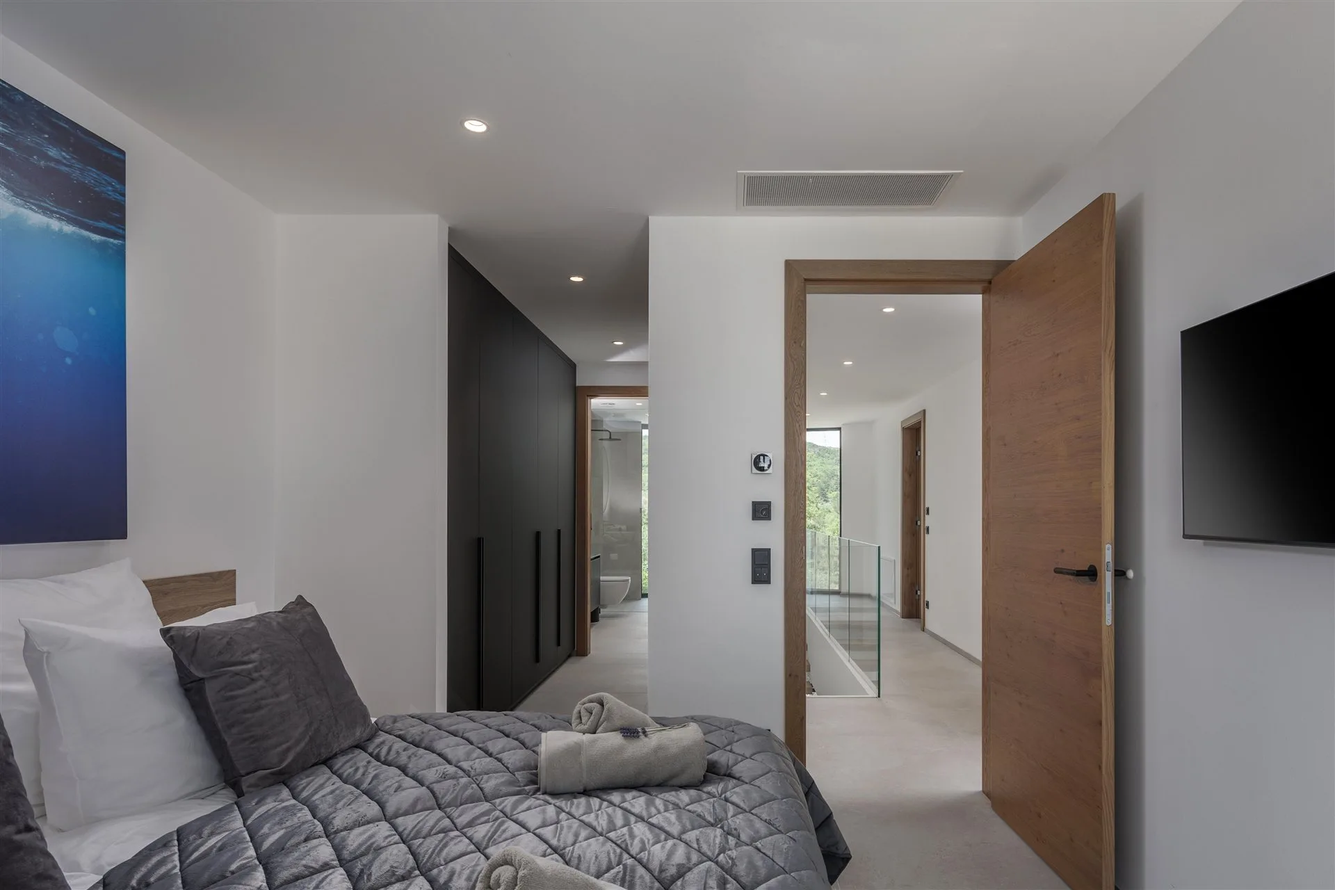 Villa Moana second bedroom — modern interior with en-suite access and ocean artwork