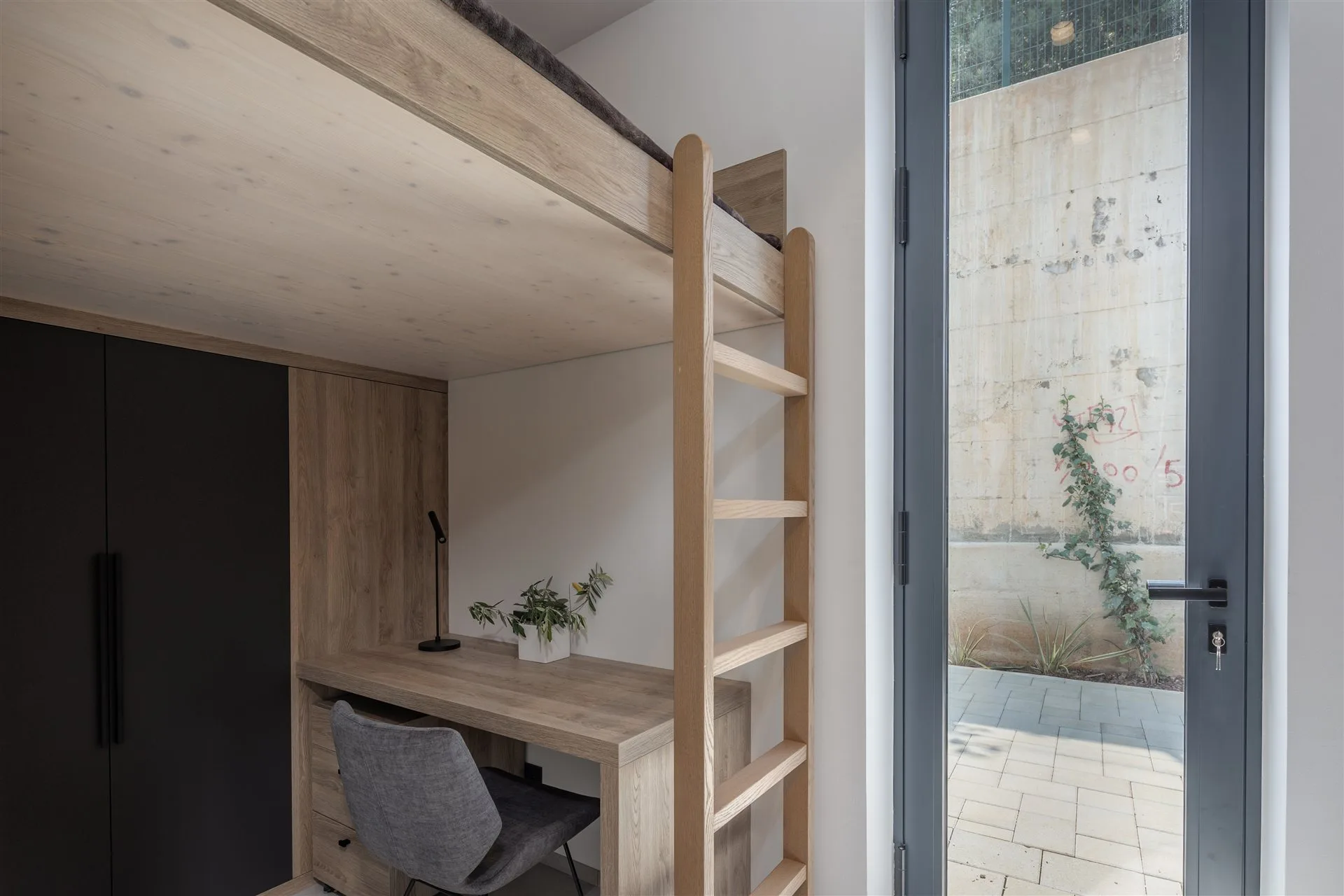 Villa Moana flex room — loft bed with wooden ladder, private desk and courtyard access