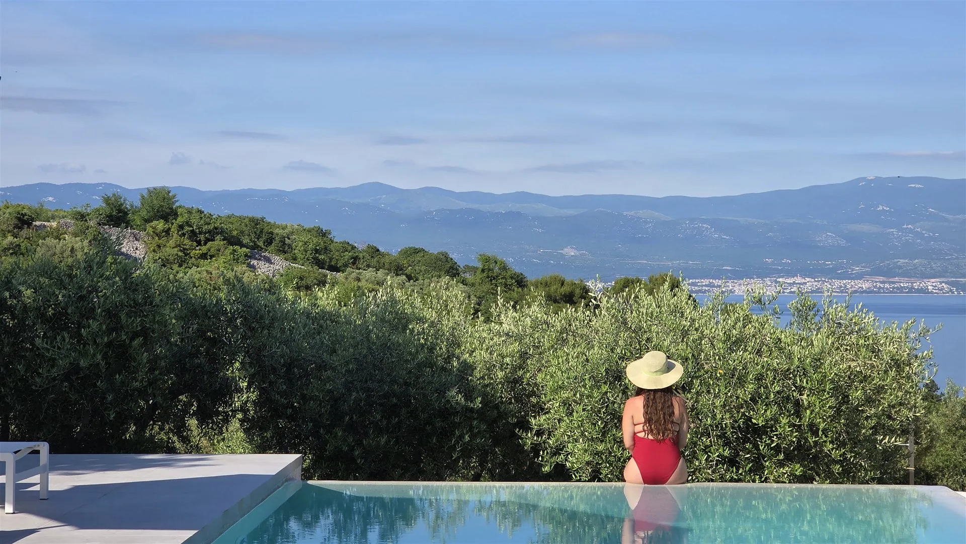 Villa Moana 12-metre infinity pool — guest at the edge, Adriatic view beyond