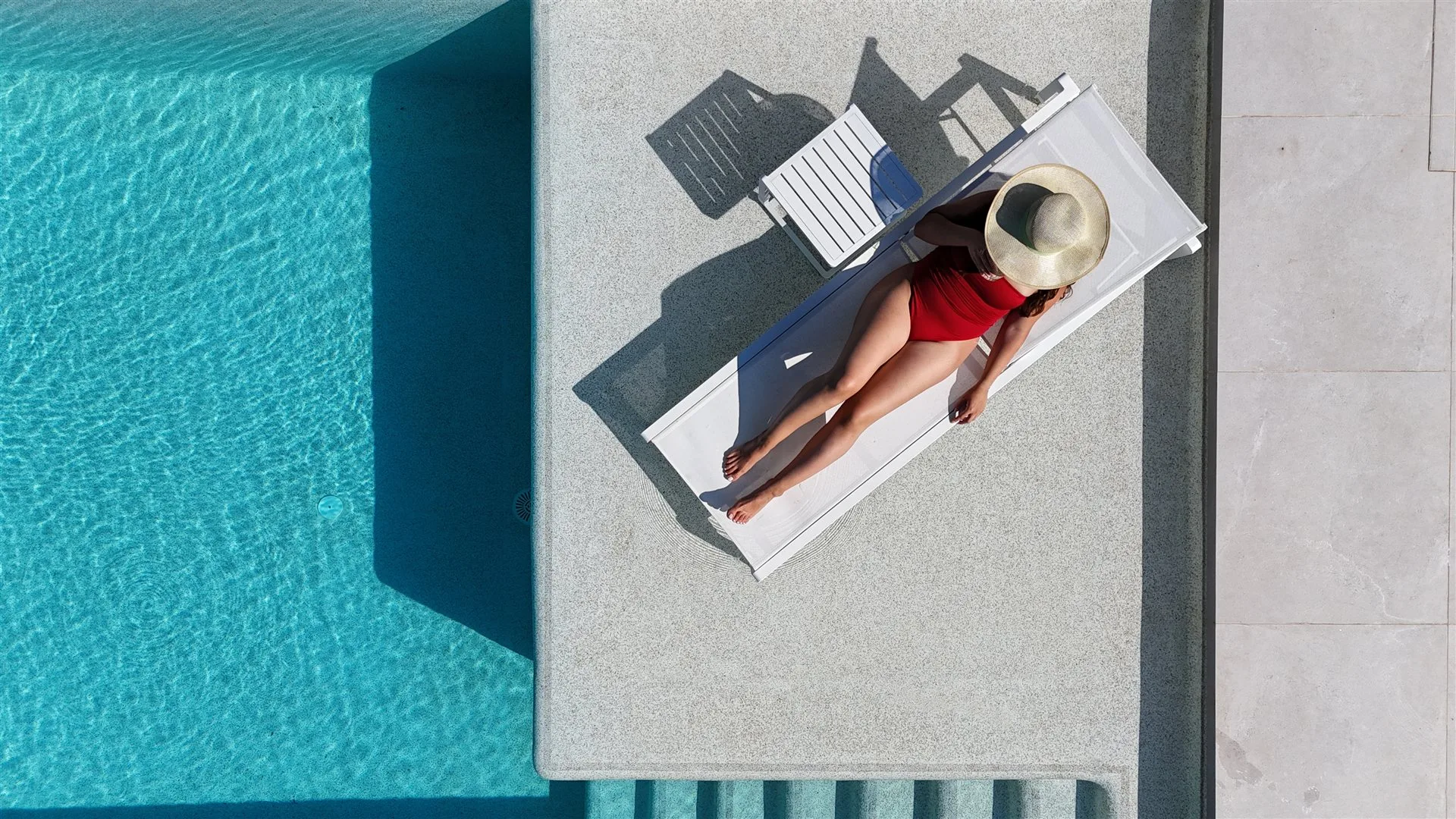 Villa Moana pool life — overhead drone view of sun lounger beside crystal-blue 12m pool