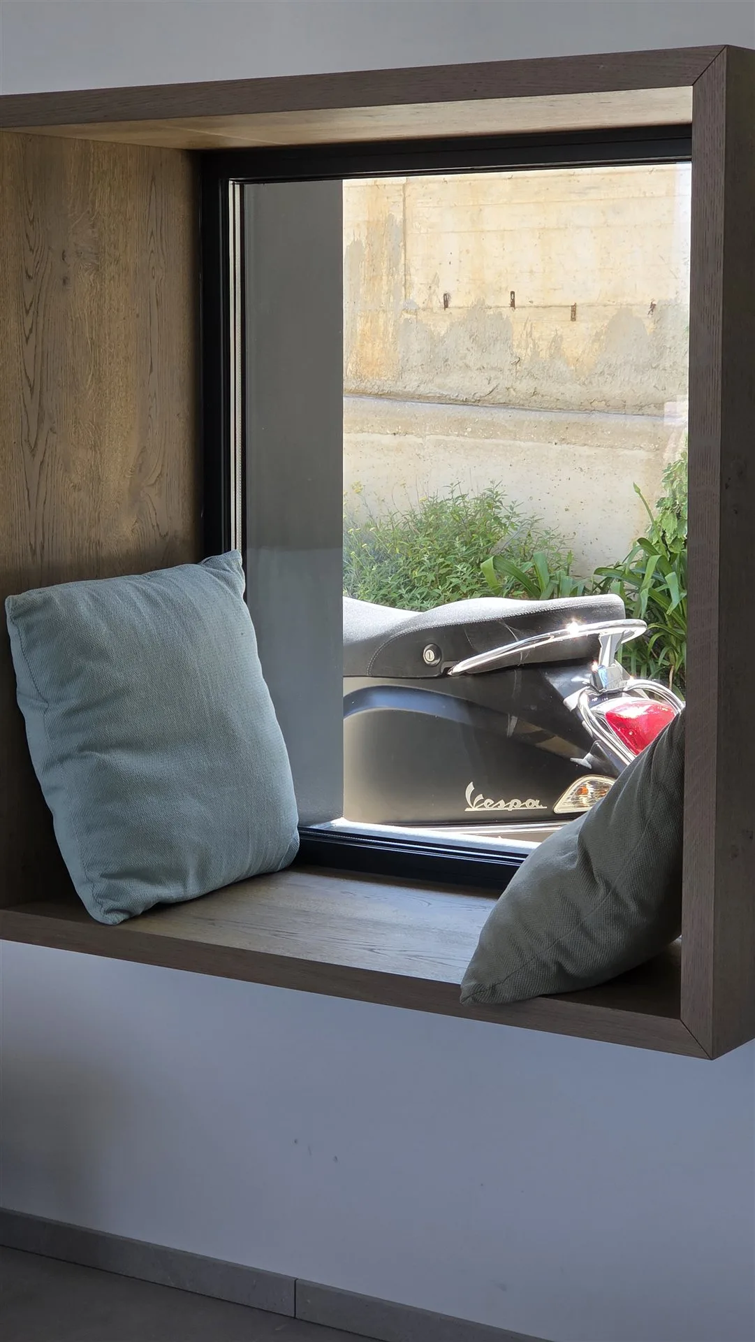 Vespa scooter seen through the Villa Moana window — included and fuelled for guests